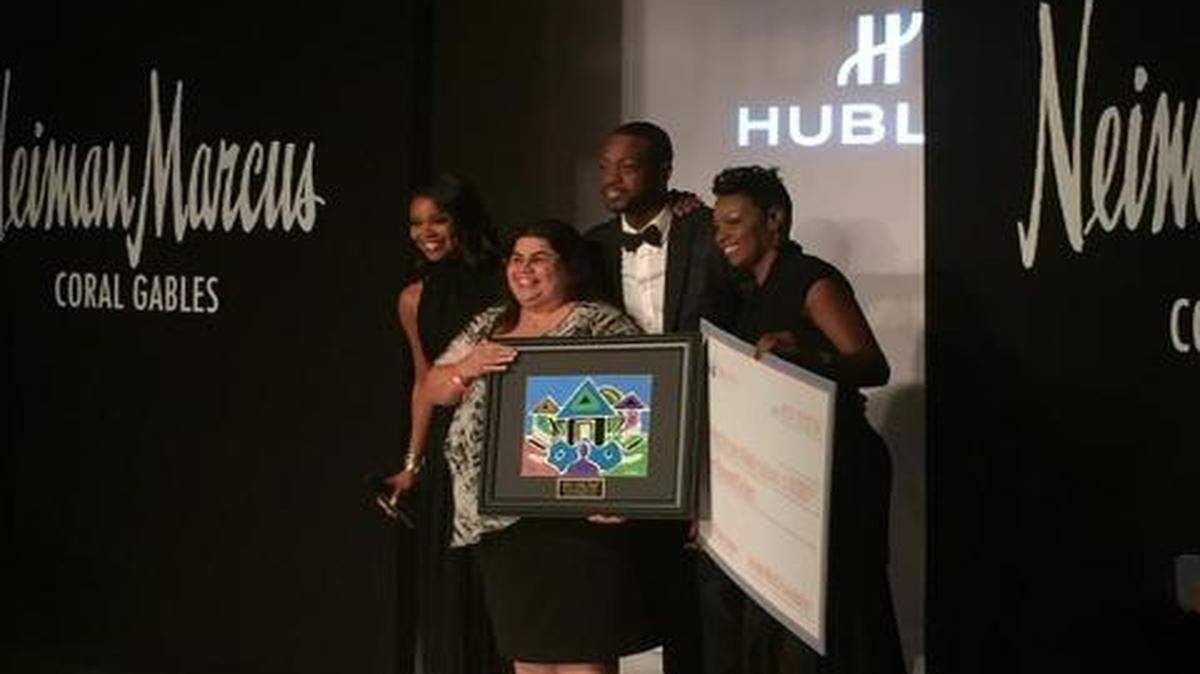 
Generosity: Dwyane Wade presents a $10,000 check to Ponce de Leon Middle School principal Martha C. Chang as part of Wade’s World Foundation. 

