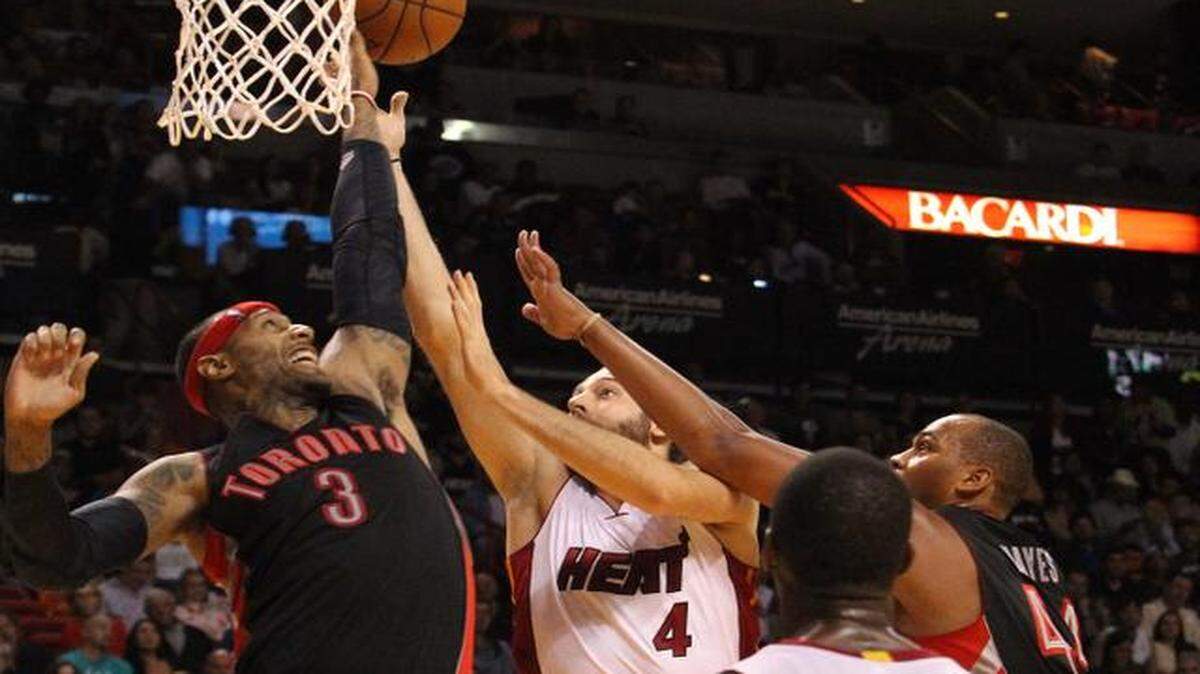 
Miami Heat’s Josh McRoberts goes between Toronto Raptors’ James Johnson and Chuck Hayes in the fourth quarter to defend at the AmericanAirlines Arena on Sunday, Nov. 2, 2014.
