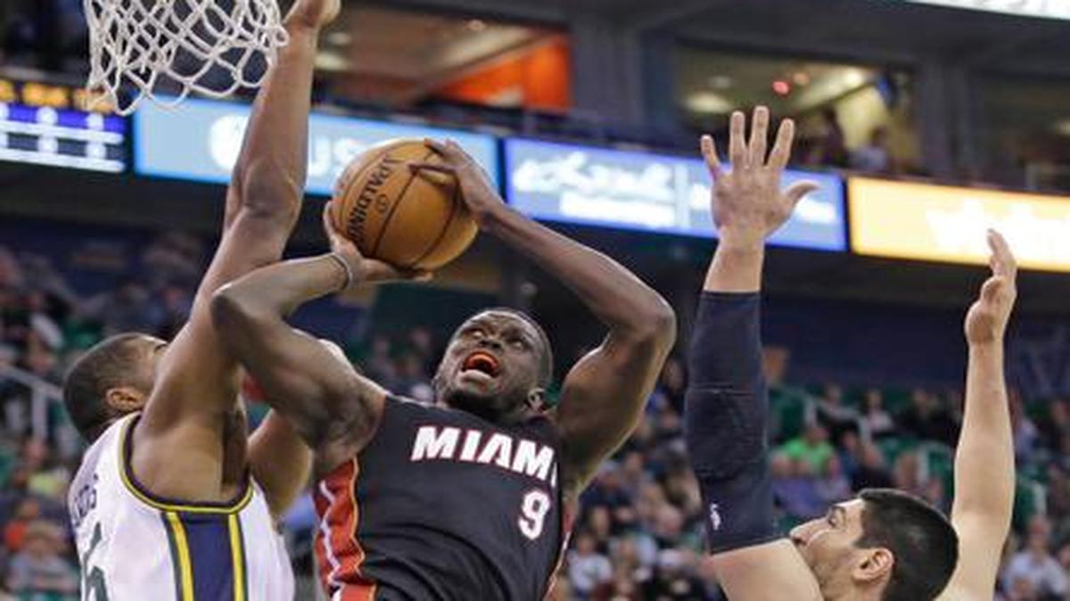 
The Heat’s Luol Deng goes to the basket as the Jazz’s Derrick Favors, left, and Enes Kanter defend in the first quarter of their game at EnergySolutions Arena, Friday, Dec. 12, 2014. Deng scored 14 for Miami. 
