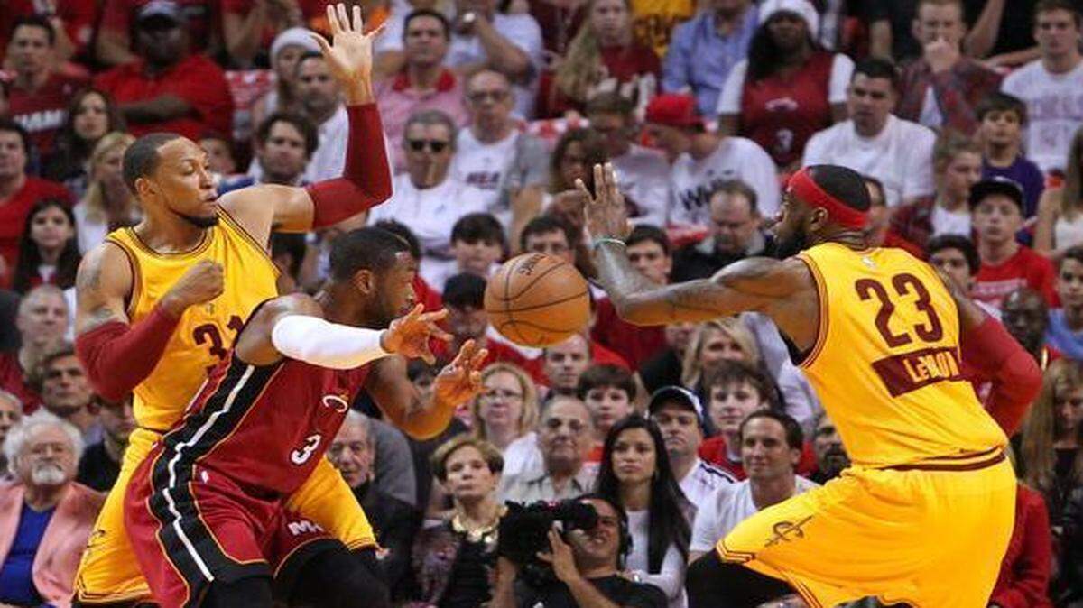 
Heat guard Dwyane Wade passes the ball between the Cleveland Cavaliers’ LeBron James, right, and Shawn Marion at AmericanAirlines Arena in Miami on Thursday, Dec. 25, 2014. 
