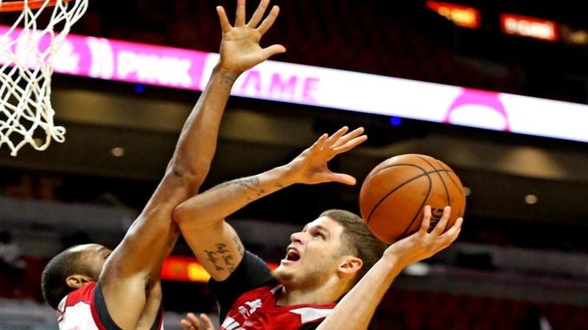 Miami Heat's Tyler Johnson drives to the basket over Wayne Ellington during the Heat's annual Red, White and Pink game at the AmericanAirlines Arena in Miami, Florida on Mon., Oct. 10, 2016.