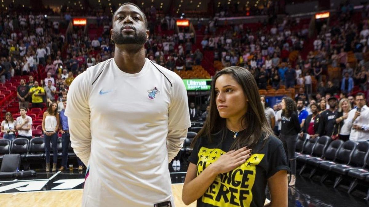 Miami Heat's Dwyane Wade stands next to Andrea Ghersi, the sister of Joaquin Oliver, 17, who was killed in the Marjory Stoneman Douglas High School shooting, during the singing of the National Anthem before the Heat faced the Pistons at the AmericanAirlines Arena on March 3, 2018.