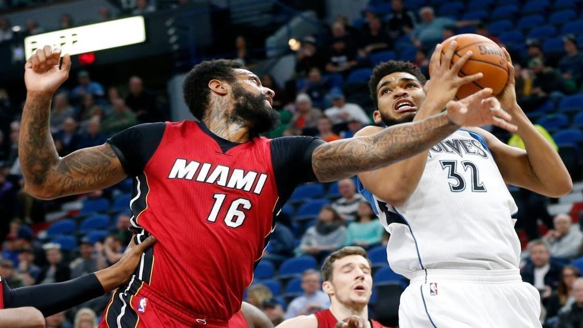 Minnesota Timberwolves center Karl-Anthony Towns, right, eyes the basket as Miami Heat forward James Johnson defends during the first quarter of an NBA basketball game in Minneapolis on Feb. 6, 2017.