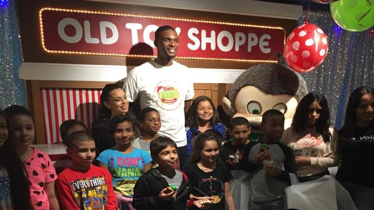Miami Heat forward Chris Bosh takes a picture with children at the annual Christmas with Chris Bosh event at Game Time Miami on Saturday, December 19, 2015.