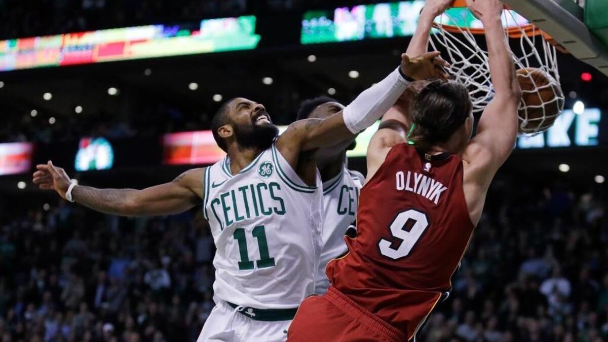 Miami Heat center Kelly Olynyk beats Boston Celtics guard Kyrie Irving to the basket for a dunk during the second half of an NBA basketball game in Boston, Wednesday, Dec. 20, 2017. The Heat won 90-89.