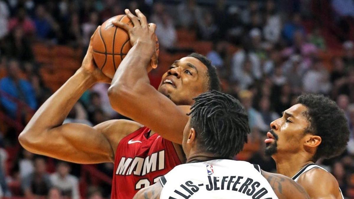 The Heat’s Hassan Whiteside muscles his way to the basket against two Nets defenders Friday night.