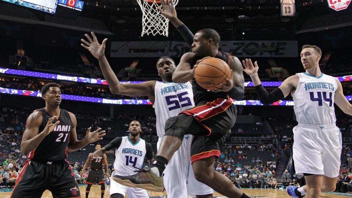 Miami Heat's Dion Waiters, center, looks to pass as Charlotte Hornets' Roy Hibbert (55) defends in the first half of a preseason NBA basketball game in Charlotte, N.C., Thurs., Oct. 20, 2016.