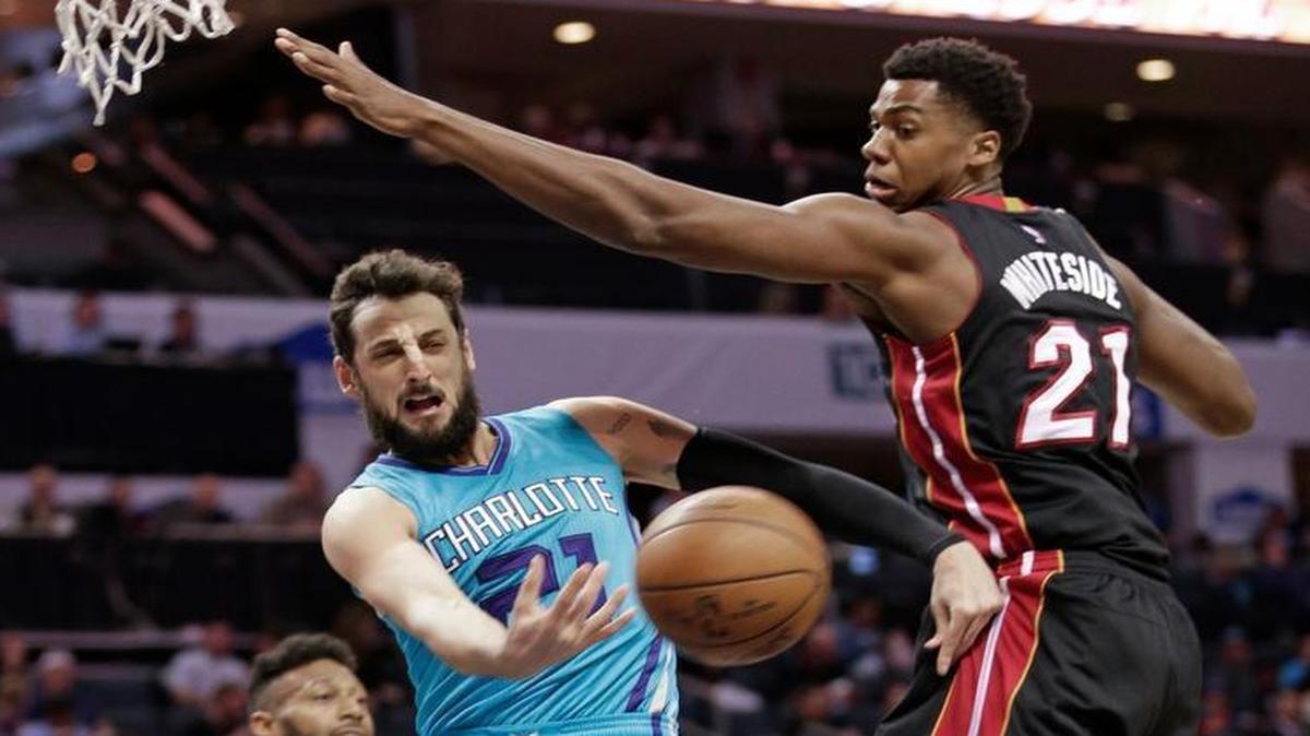 Charlotte Hornets' Marco Belinelli, left, passes the ball around Miami Heat's Hassan Whiteside during the first half of an NBA basketball game in Charlotte, N.C., Wednesday, April 5, 2017.