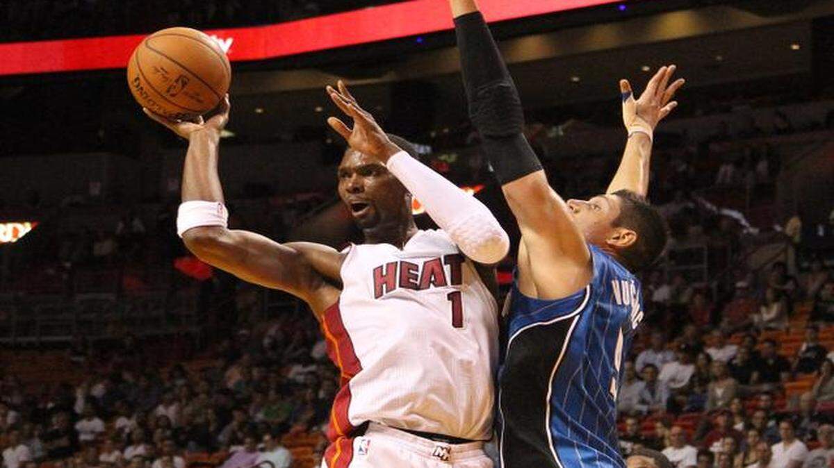 
 Chris Bosh looks on to pass the ball against Nikola Vucevic in the second quarter during the Miami Heat's preseason game against the Orlando Magic at AmericanAirlines Arena in Miami on Tuesday, Oct. 7, 2014.
