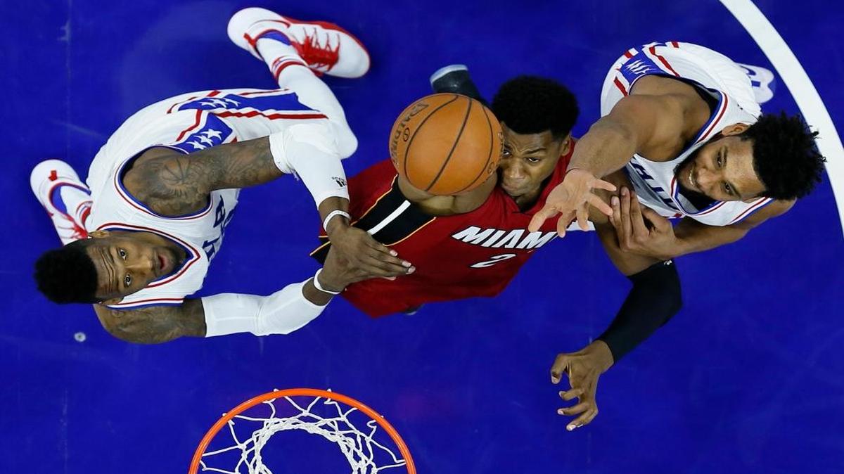 Miami Heat's Hassan Whiteside, center, goes up for a shot between Philadelphia 76ers' Robert Covington, left, and Jahlil Okafor during the second half of an NBA basketball game, Mon., Nov. 21, 2016, in Philadelphia. Philadelphia won 101-94.