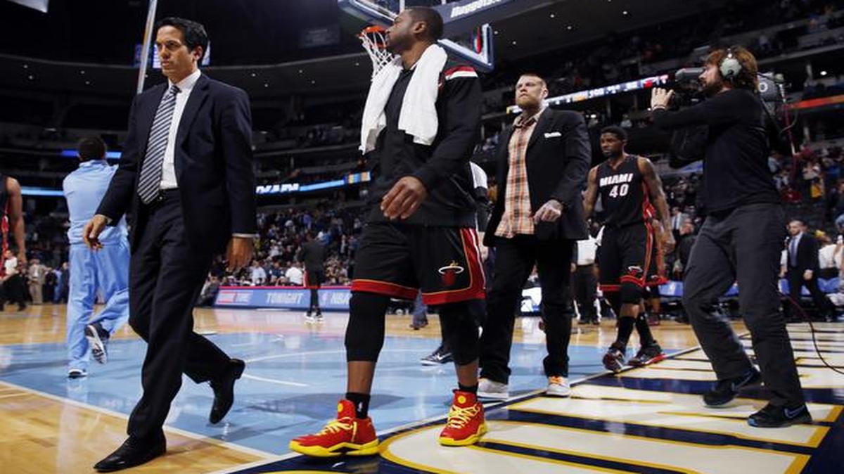 
Miami Heat head coach Erik Spoelstra, left, guard Dwyane Wade and center Chris Andersen head off the court after the Denver Nuggets' 102-82 victory over the Heat in an NBA basketball game in Denver on Wednesday, Dec. 10, 2014. 
