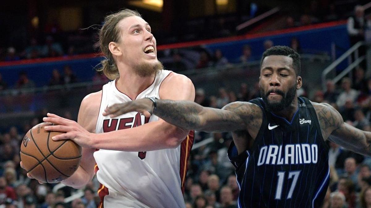 Miami Heat center Kelly Olynyk, left, is fouled by Orlando Magic forward Jonathon Simmons (17) while going up to shoot during the second half of an NBA basketball game Saturday, Dec. 30, 2017, in Orlando, Fla.