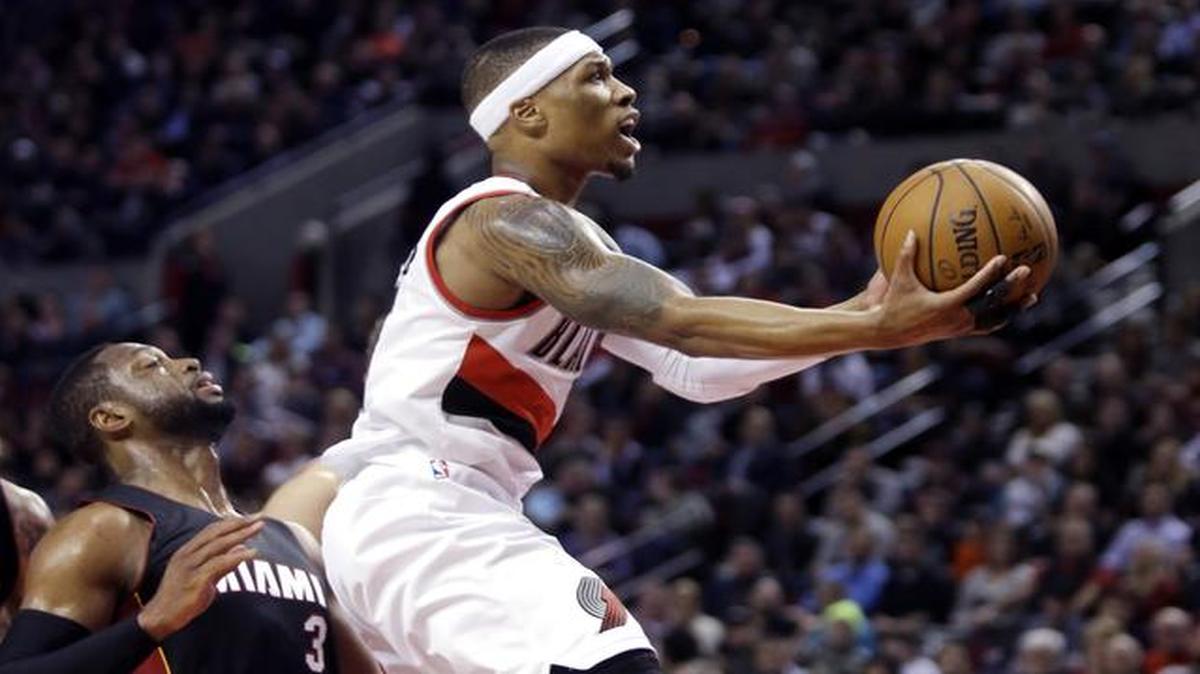 
Portland Trail Blazers guard Damian Lillard, right, drives to the basket past Miami Heat guard Dwyane Wade during the second half of an NBA basketball game in Portland, Ore., Thursday, Jan. 8, 2015. Lillard scored 16 points as the Blazers defeated the Heat 99-83.
