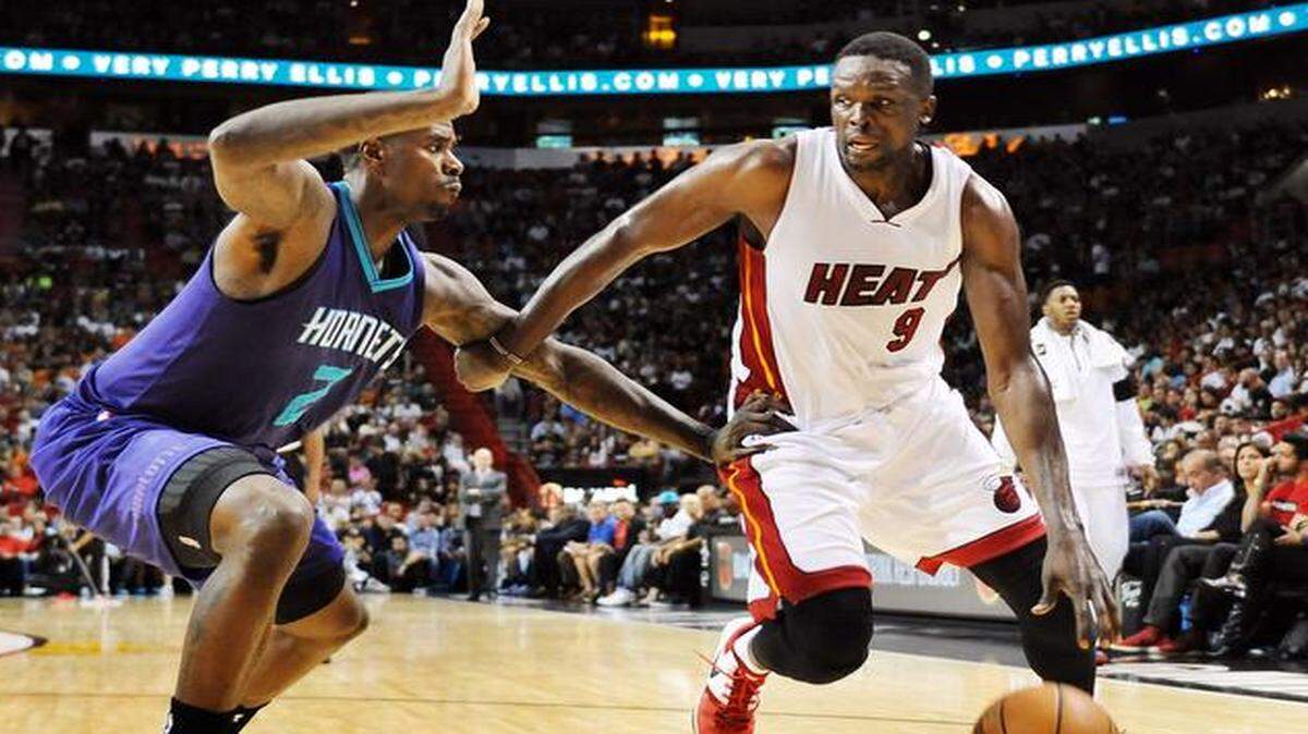 
Miami Heat forward Luol Deng dribbles past the Charlotte Hornets’ Bismack Biyombo during the first half Sunday, Nov. 23, 2014 at AmericanAirlines Arena in Miami. 

