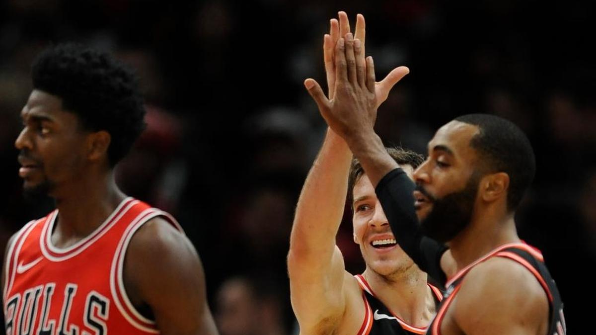 Miami Heat's Goran Dragic of Slovenia, back, celebrates with teammate Wayne Ellington front, while Chicago Bulls' Justin Holiday (7) looks on after Dragic made a basket while being fouled during the final minutes of the second half of an NBA basketball game Sun., Nov. 26, 2017, in Chicago. Miami won 100-93.