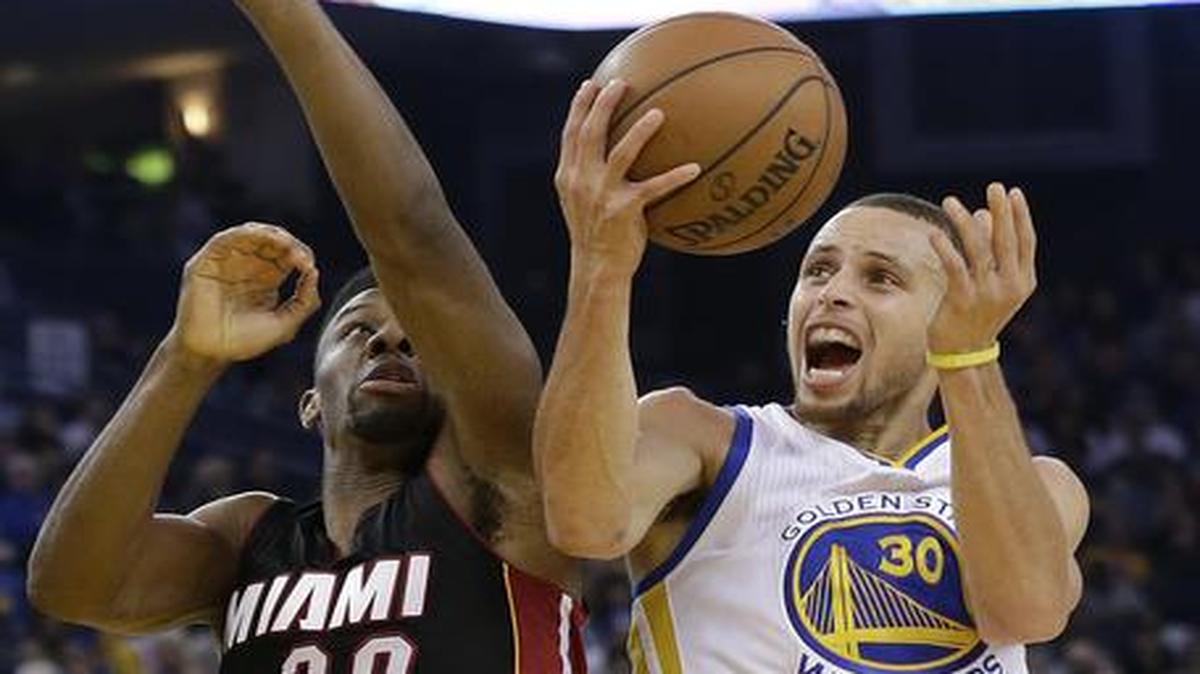 
Golden State Warriors guard Stephen Curry shoots against Miami Heat guard Norris Cole during the second half of an NBA basketball game in Oakland, Calif., Wednesday, Jan. 14, 2015. The Warriors won 104-89. 
