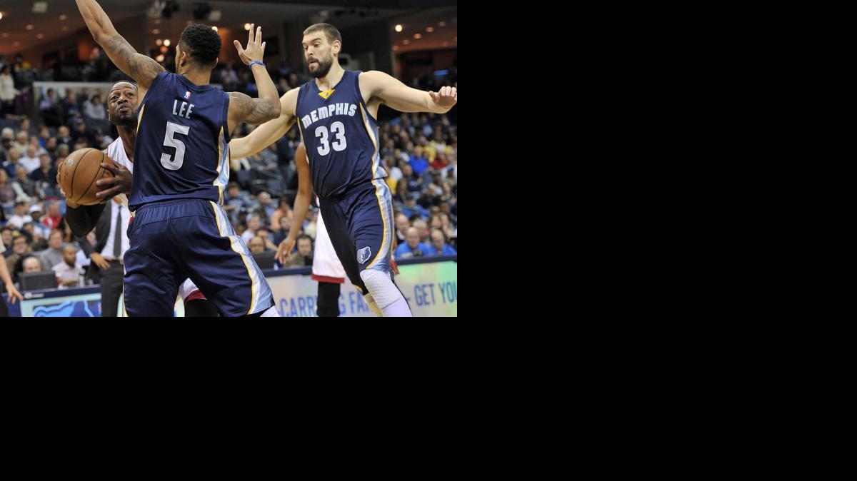 
Miami Heat guard Dwyane Wade (3) looks to shoot around Memphis Grizzlies guard Courtney Lee (5) and center Marc Gasol (33) in the first half of an NBA basketball game Sunday, Dec. 7, 2014, in Memphis, Tenn. 
