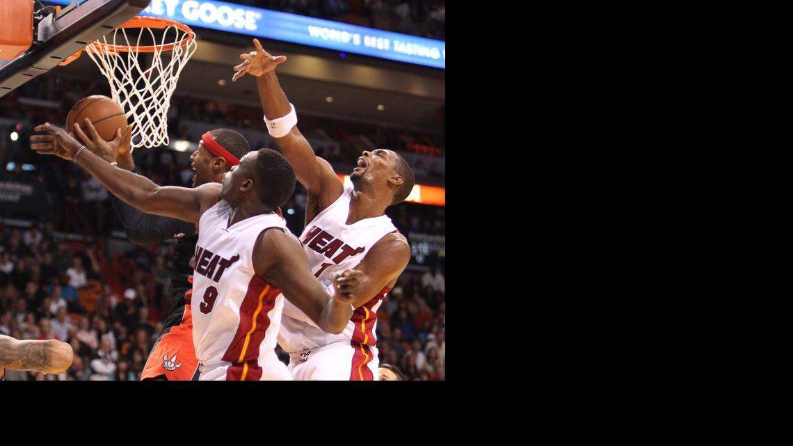 
Miami Heat’s Loul Deng (9) and Chris Bosh (1) trying to block the shot of Toronto Raptors’ James Johnson in the second quarter at the AmericanAirlines Arena on Sunday, Nov. 2, 2014.
