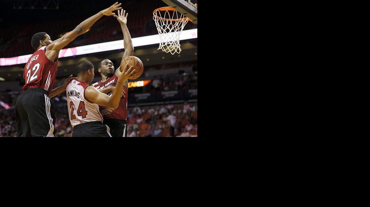 
New faces: Heat guard Andre Dawkins goes to the basket against forwards Danny Granger and Shawn Jones during a scrimmage at AmericanAirlines Arena on Wednesday.
