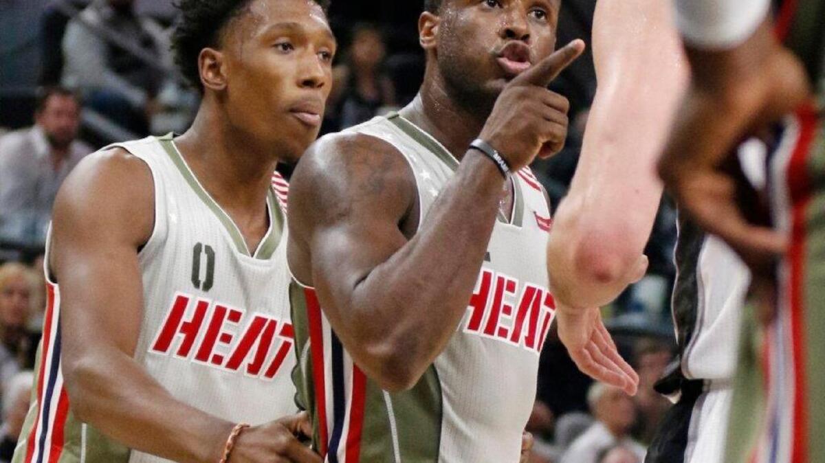 Heat guard Josh Richardson (0) restrains teammate Dion Waiters (11) during the Heat’s 94-90 loss to San Antonio on Monday.