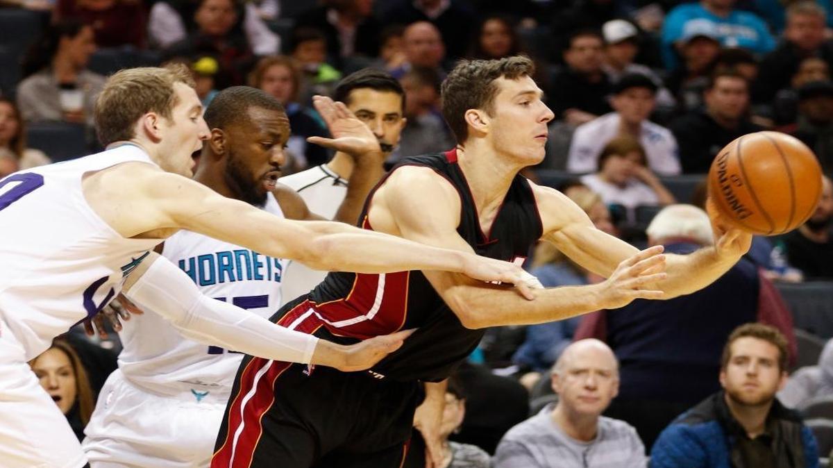 Miami Heat guard Goran Dragic, of Slovenia, escapes a double team by Charlotte Hornets' Cody Zeller, left, and Kemba Walker during the second half of an NBA basketball game in Charlotte, N.C., Thurs., Dec. 29, 2016. Charlotte won 91-82.