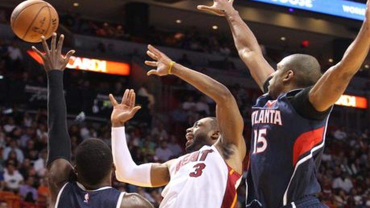 
Dwyane Wade battles for a loose ball against Al Horford and Shelvin Mack in the second quarter of the Miami Heat's game against the Atlanta Hawks at AmericanAirlines Arena in Miami on Wednesday, Dec. 3, 2014.
