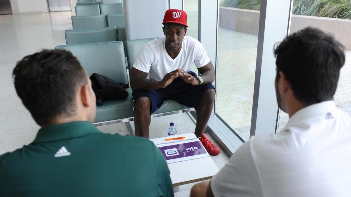Former NFL player Phillip Buchanan talks to UM students Nolan Chasten, left, and Chris Guerrero, right, about a new app.