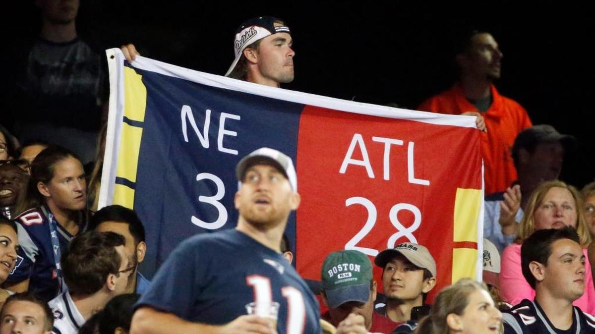 Fans hold up a banner reflecting the third quarter score from the New England Patriots and Atlanta Falcons from Super Bowl LI during an NFL preseason football game against the Jacksonville Jaguars, Thursday, Aug. 10, 2017, in Foxborough, Mass.