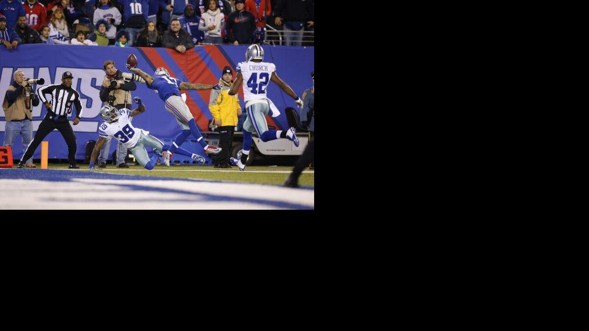 
New York Giants wide receiver Odell Beckham Jr. (13) makes a one-handed catch for a touchdown against Dallas Cowboys cornerback Brandon Carr (39) in the second quarter of an NFL football game, Sunday, Nov. 23, 2014, in East Rutherford, N.J.
