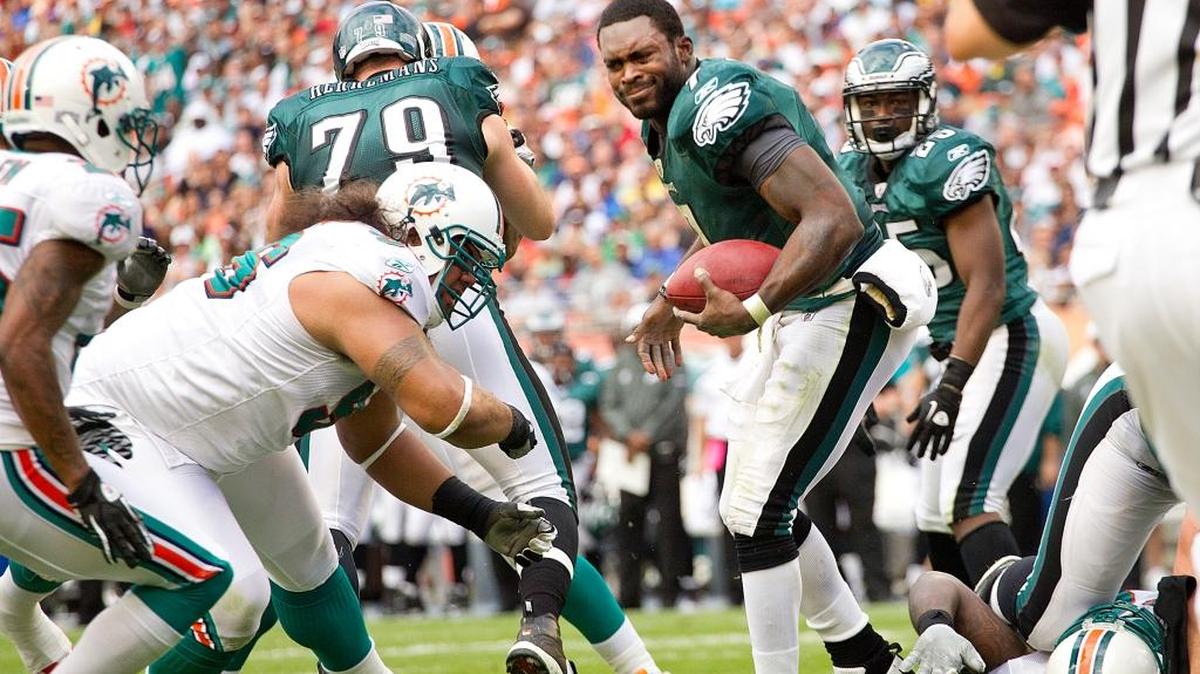 Michael Vick scrambles after having his helmet ripped off in a game against the host Miami Dolphins in 2011.
