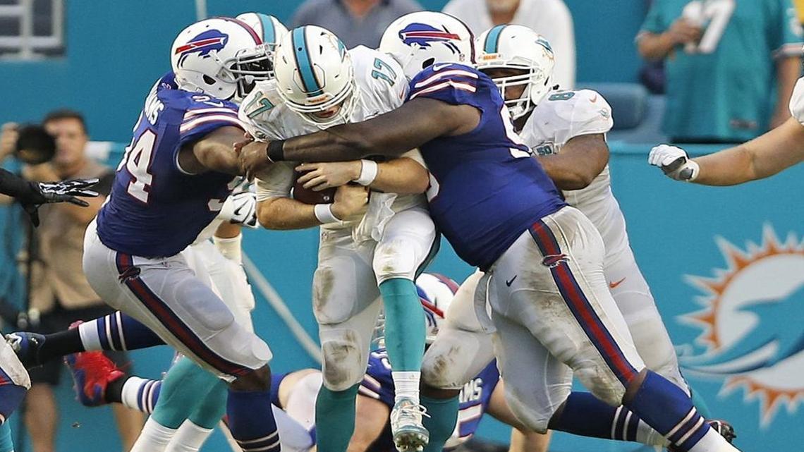 Miami Dolphins quarterback Ryan Tannehill (17) is crushed between the Buffalo Bills defensive end Mario Williams (94) and defensive tackle Marcell Dareus (99) on Sept. 27, 2015.