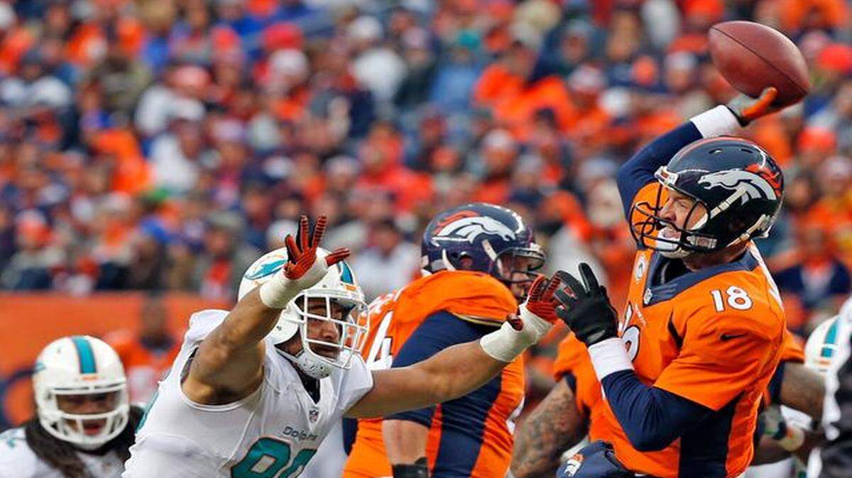 
Miami Dolphins defender Jared Odrick tries to rush Denver Broncos quarterback Peyton Manning in the third quarter at Sports Authority Field at Mile High in Denver, Colorado, Nov. 23, 2014.

