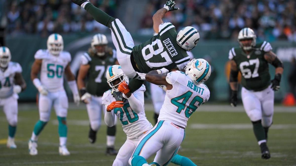 Dolphins linebacker Neville Hewitt (46) teams with safety Reshad Jones (20) to tackle New York Jets receiver Eric Decker (87) on Sunday, Nov. 29, 2015, in East Rutherford, N.J.