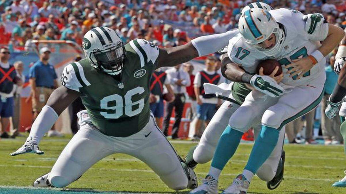 
Miami Dolphins quarterback Ryan Tannehill is sacked on the opening drive by New York Jets defender Muhammad Wilkerson in the first quarter as they play the New York Jets at Sun Life Stadium in Miami Gardens on Sunday, Dec. 28, 2014.
