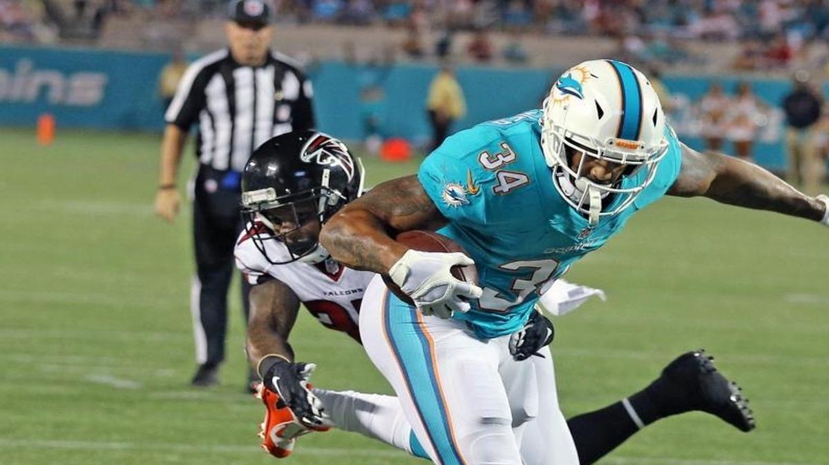 Miami’s Arian Foster breaks a tackle by Atlanta’s Ricardo Allen to score in the second quarter on Thursday night.