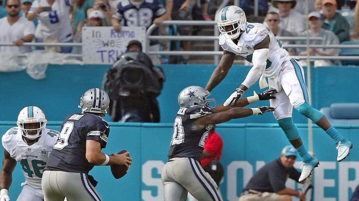 Miami Dolphins Reshad Jones leaps up as Dallas Cowboys Darren McFadden blocks him as Cowboys quarterback Tony Romo looks for a reciever in the first quarter at Sun Life Stadium in Miami Gardens, Florida, November 22, 2015.