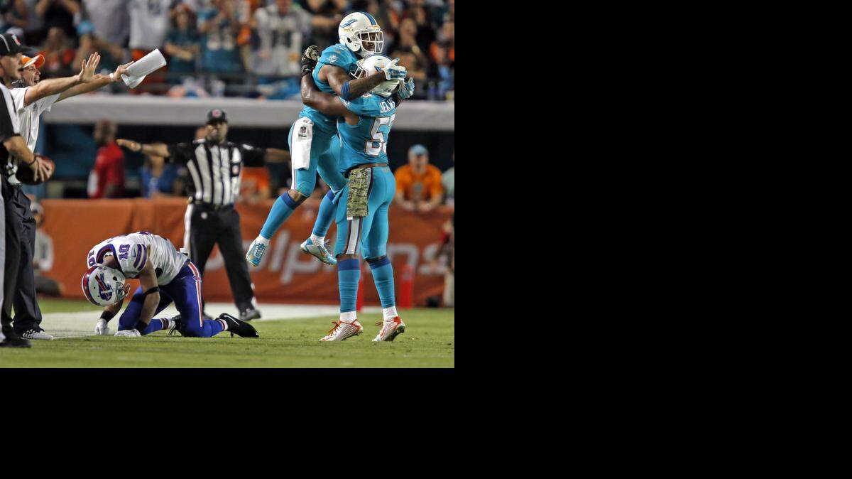 
Miami Dolphins defensive back Jamar Taylor (22) and linebacker Jelani Jenkins (53) celebrate after breaking up a pass to Buffalo Bills wide receiver Robert Woods in the fourth quarter of their game at Sun Life Stadium in Miami Gardens on Nov. 13, 2014.
