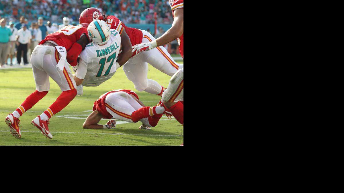 
Miami Dolphins quarterback Ryan Tannehill gets squeezed between Kansas City Chiefs defenders Husain Abdullah and Dontari Poe as Tannehill moves the ball to help setup a field goal at the end of the second quarter at Sun Life Stadium in Miami Gardens, Fla., on Sunday, Sept. 21, 2014. 
