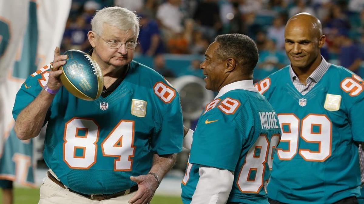 In this Dec. 14, 2015, file photo, former Miami Dolphins player Bill Stanfill (84) is presented a football by former player and current Dolphins senior vice president of special projects and alumni relations, Nat Moore (89) during the Dolphins All-Time 50th Anniversary Team ceremony during half time at an NFL football game against the New York Giants, in Miami Gardens, Fla. Former Georgia and Miami Dolphins star Bill Stanfill has died. He was 69. The university issued a statement on behalf of Stanfill's family saying he died Thursday night, Nov. 10, 2016, in Albany, Ga.
