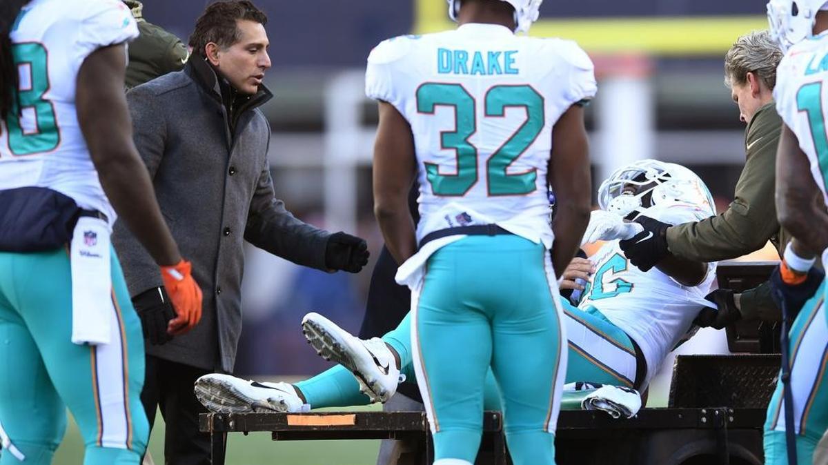 Miami Dolphins running back Damien Williams (26) leaves the field with an injury as running back Kenyan Drake (32) looks on in a game against the New England Patriots on Nov. 26.