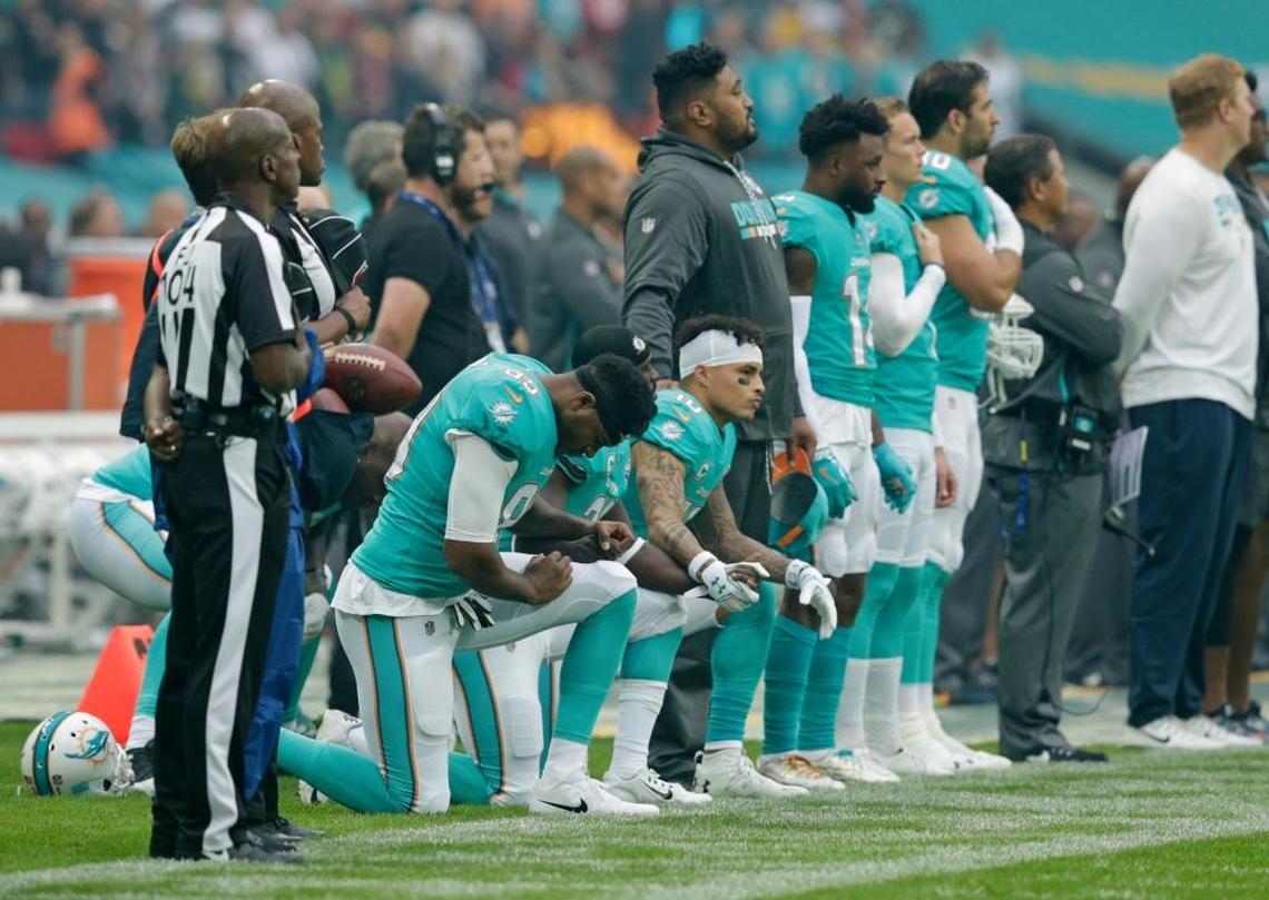 Miami Dolphins players kneel down during the national anthem before the NFL game between the Miami Dolphins and the New Orleans Saints at Wembley Stadium on October 1, 2017 in London, England.