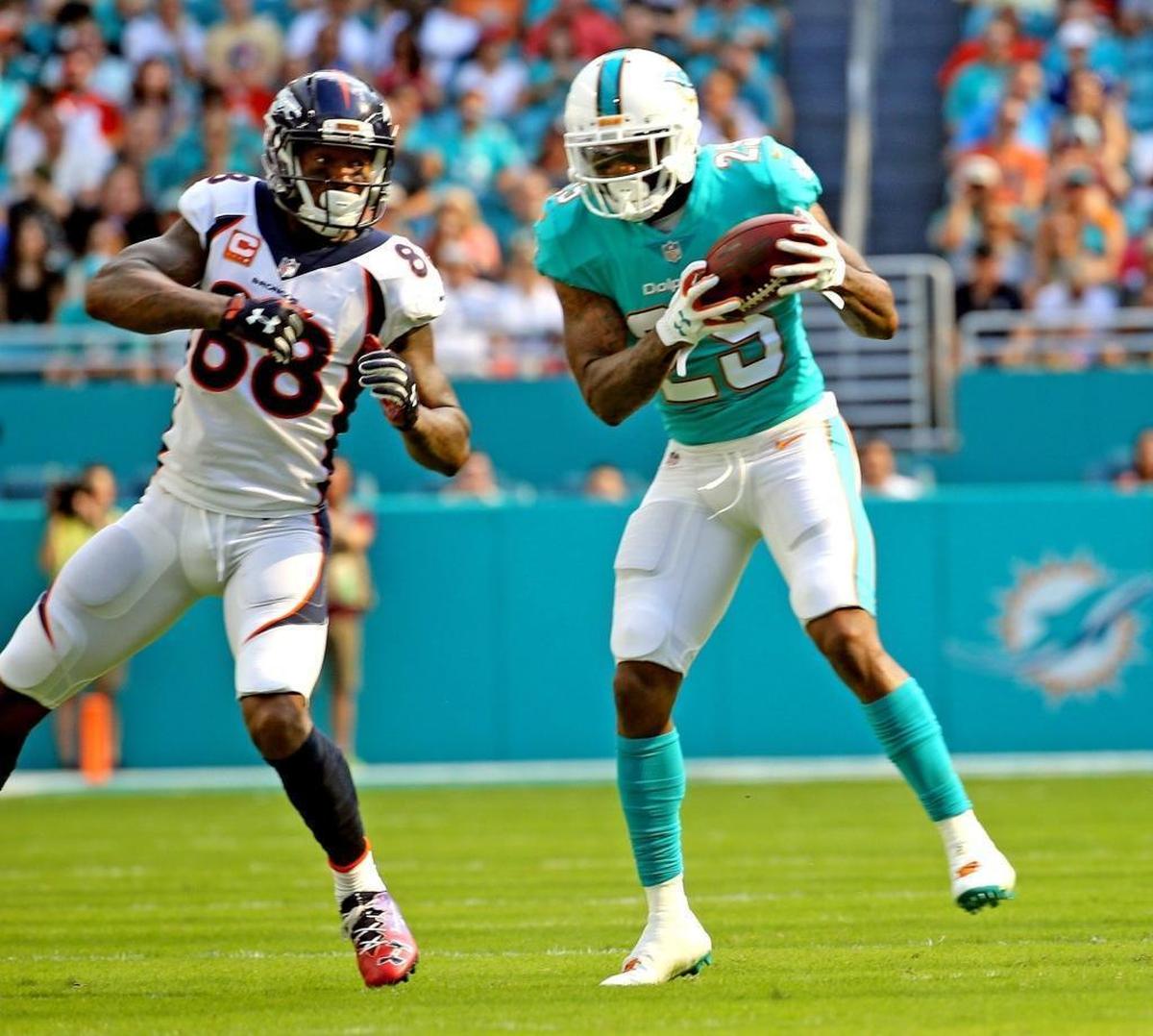 Miami Dolphins Xavien Howard intercepts the ball for a pick-six off (25) Denver Broncos Demaryius Thomas (88) in the second quarter at Hard Rock Stadium in Miami Gardens, Florida, Dec. 3, 2017.