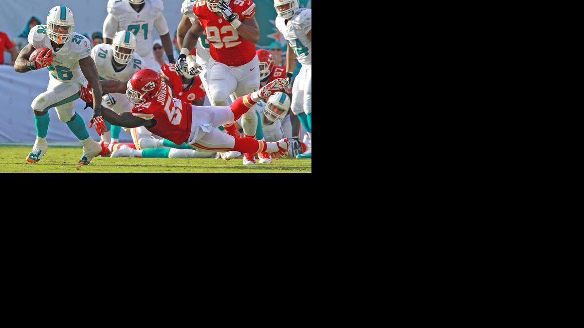 
Miami Dolphins running back Lamar Miller, right, looks up field as Kansas City Chiefs linebacker James Michael-Johnson reaches to stop him in the second quarter at Sun Life Stadium in Miami Gardens, Fla., on Sunday, Sept. 21, 2014. 
