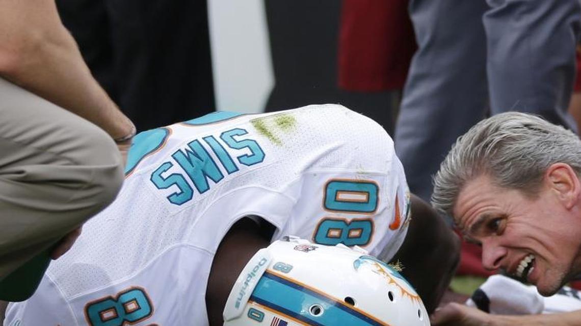 
Assistant trainer Troy Maurer checks on an injured Miami Dolphins tight end Dion Sims (80). The Washington Redskins host the Miami Dolphins at FedExField in Landover, Maryland on Sunday, September 13, 2015.
