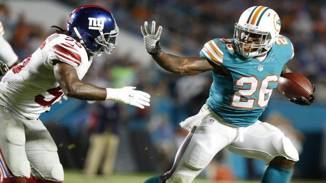 Miami Dolphins running back Lamar Miller gains yardage against the New York Giants at Sun Life Stadium on Monday, Dec. 14, 2015.