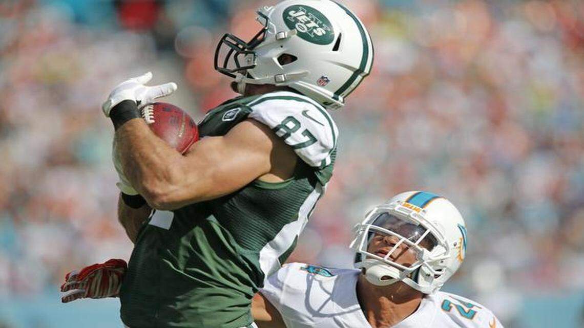 
New York Jets wide receiver Eric Decker (87) on a long pass reception as Miami Dolphins cornerback Cortland Finnegan (24) defends in the second quarter as the Miami Dolphins host the New York Jets at Sun Life Stadium on Sunday, Dec. 28, 2014.

