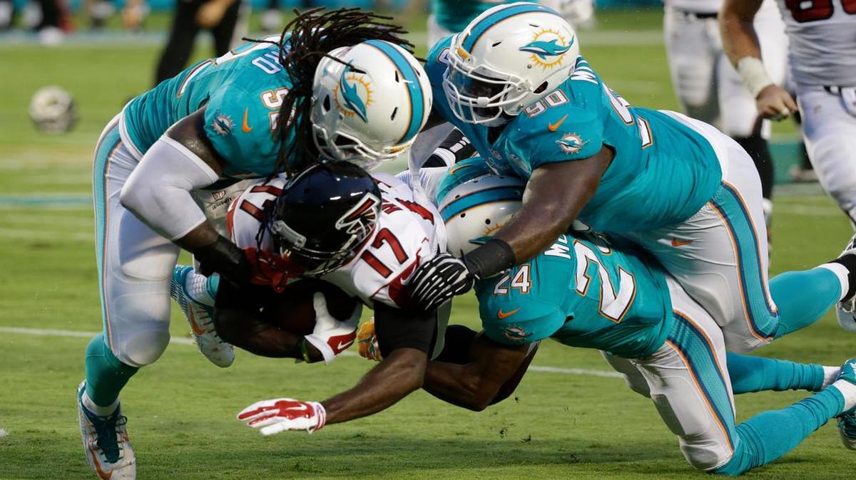 
The Dolphins’ Brice McCain (24), who started at cornerback against Atlanta, Kelvin Sheppard (52) and Earl Mitchell (90) the Falcons’ tackle Devin Hester during the first half Saturday night.
