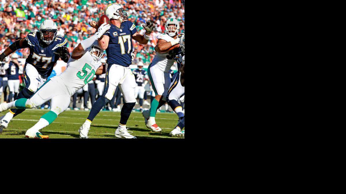 
Putting on the pressure: Dolphins defensive end Olivier Vernon strips the ball from Chargers quarterback Philip Rivers in the third quarter. The Dolphins sacked Rivers four times in the game.
