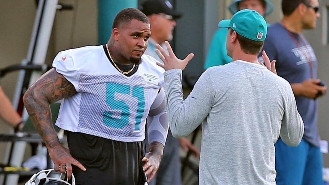 Miami Dolphins center Mike Pouncey talks with coach Adam Gase on the first day of training camp at the Miami Dolphins facility in Davie, Fl, July 27, 2017.