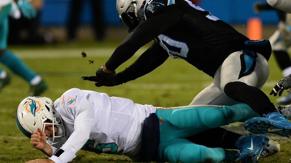 Carolina Panthers defensive end Julius Peppers makes contact with Miami Dolphins quarterback Jay Cutler Sunday night. Cutler threw a costly first-half interception.
